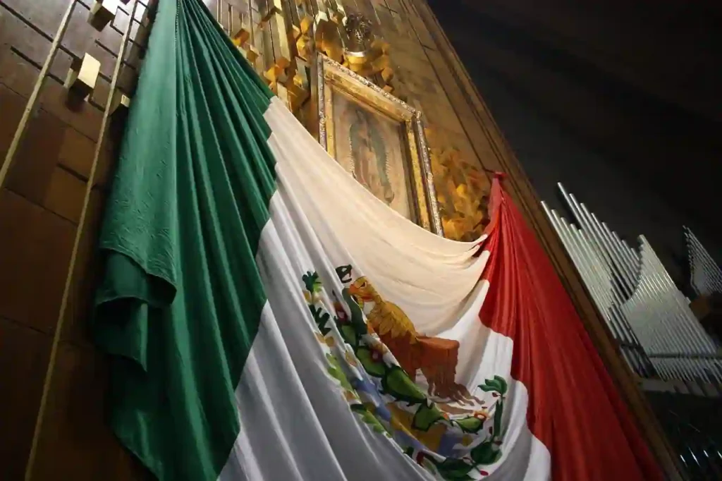 Bandeira do México tremulando ao vento em dia ensolarado, representando as exigências de visto para entrada no país por brasileiros